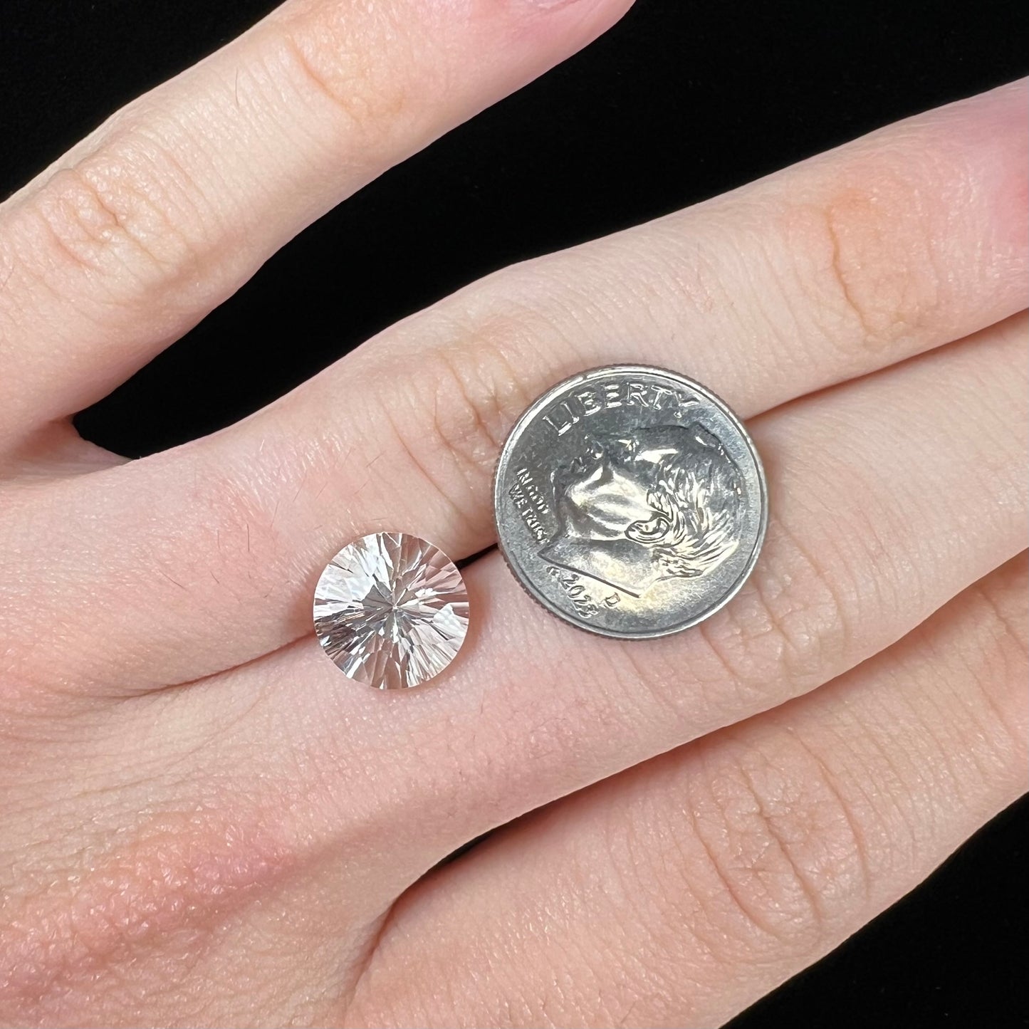 A round brilliant cut petalite gemstone. The stone is colorless.