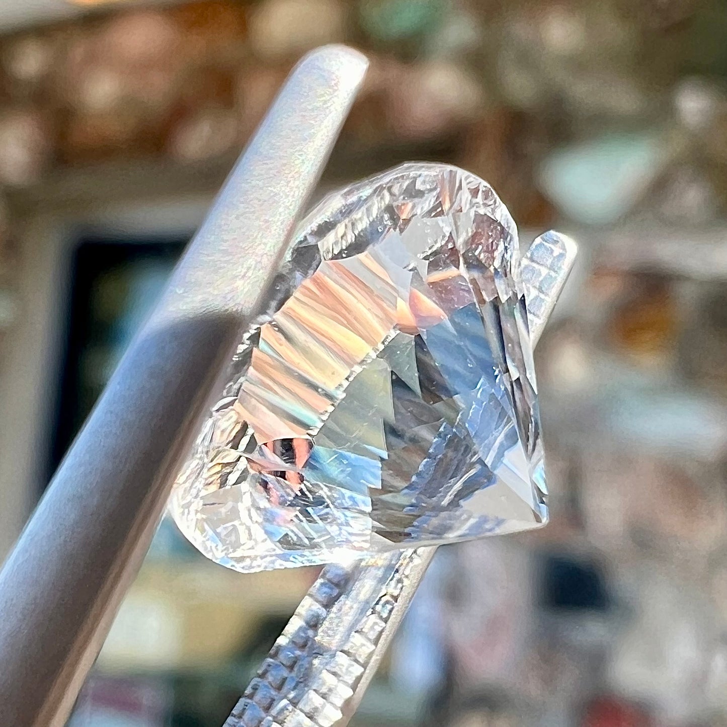 A round brilliant cut petalite gemstone. The stone is colorless.