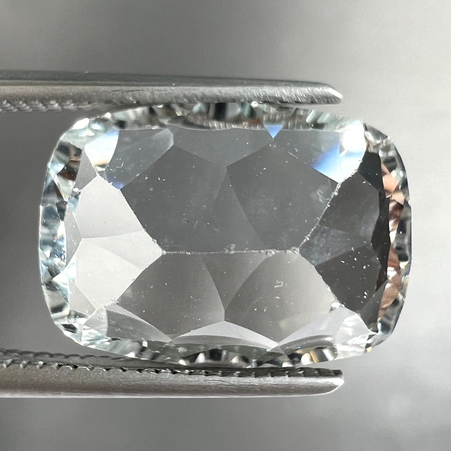 A loose, modified laser cushion cut white topaz gemstone.
