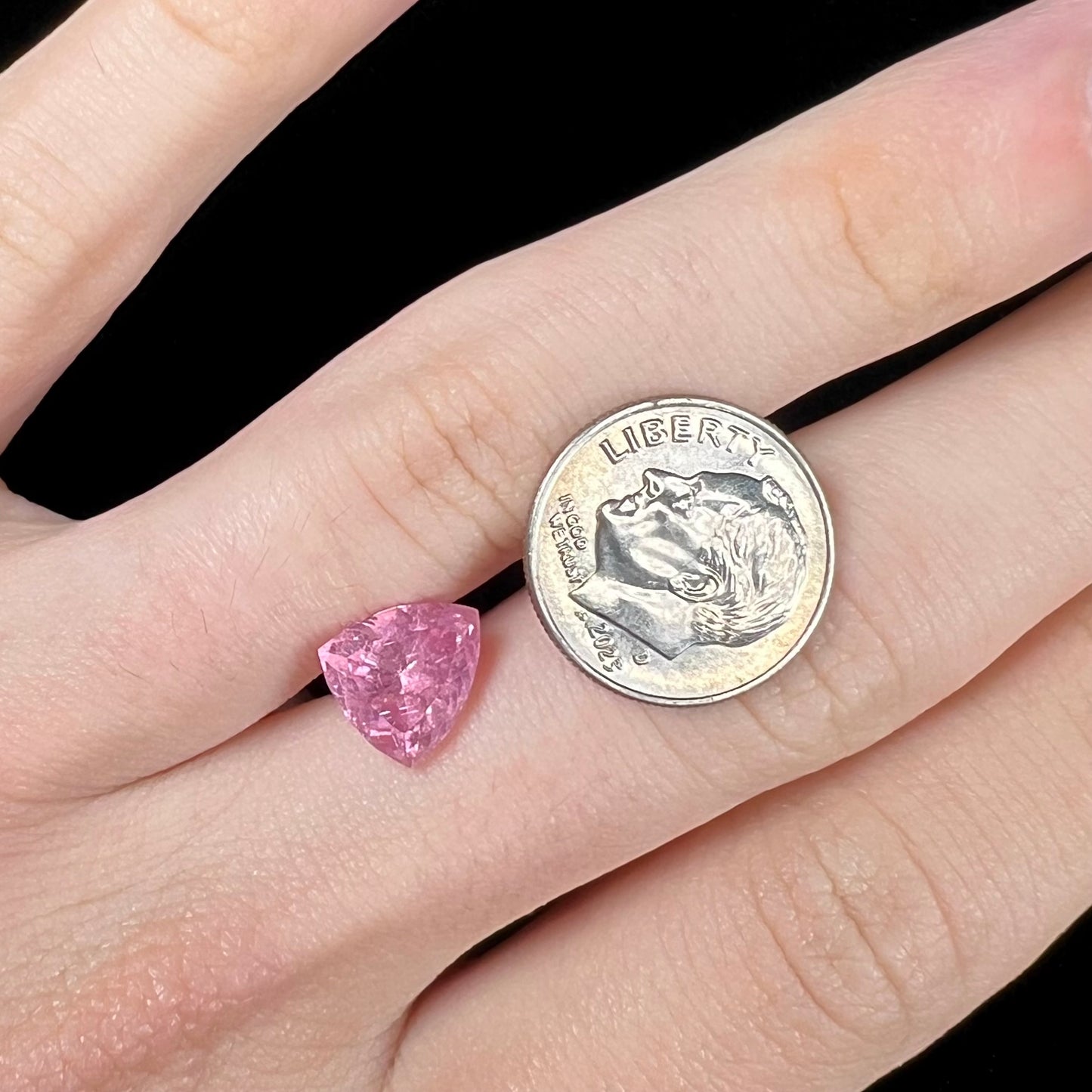 A loose, faceted trillion cut pink touramline gemstone.  The stone is a light bubblegum pink color.