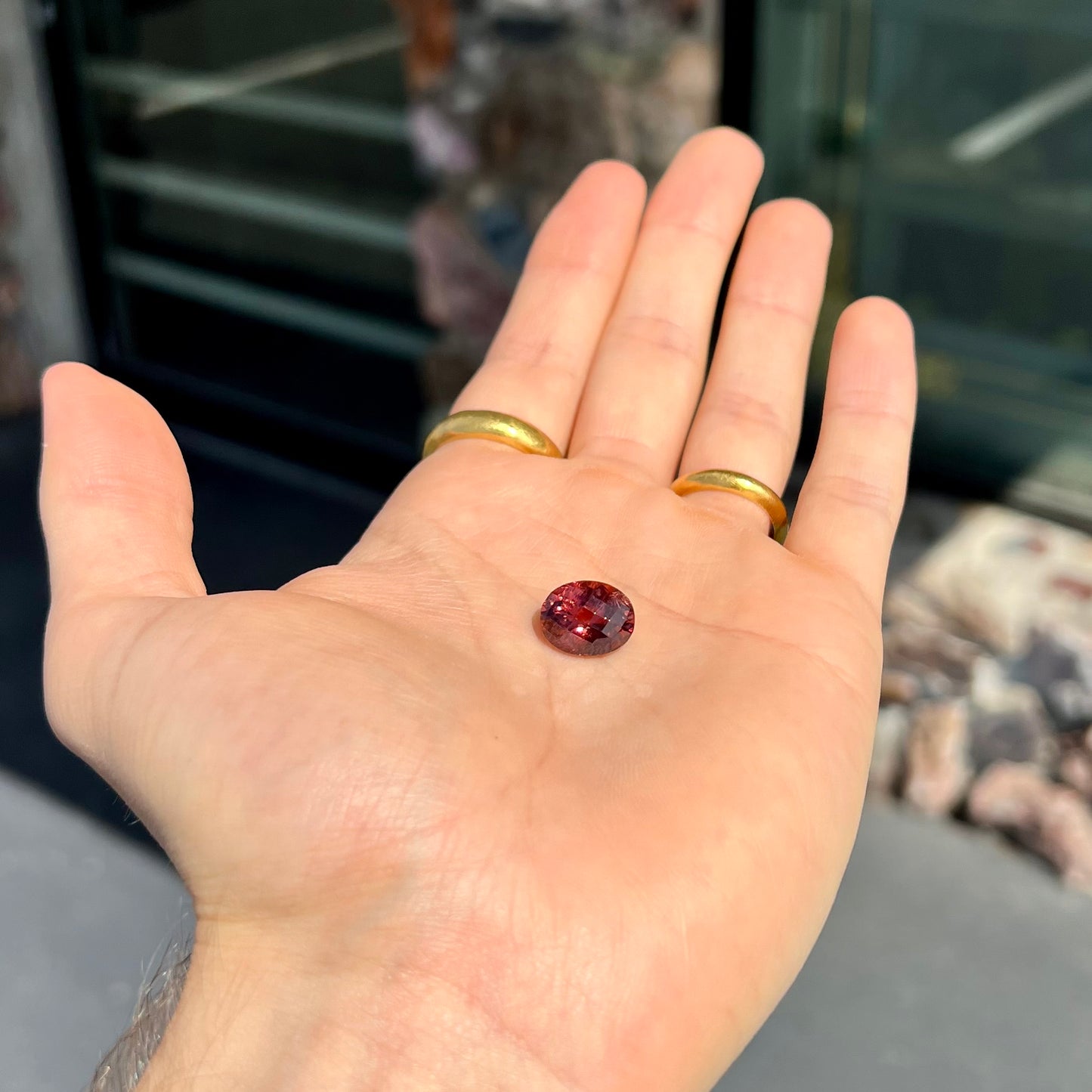 A faceted oval checkerboard cut purplish pink tourmaline gemstone.