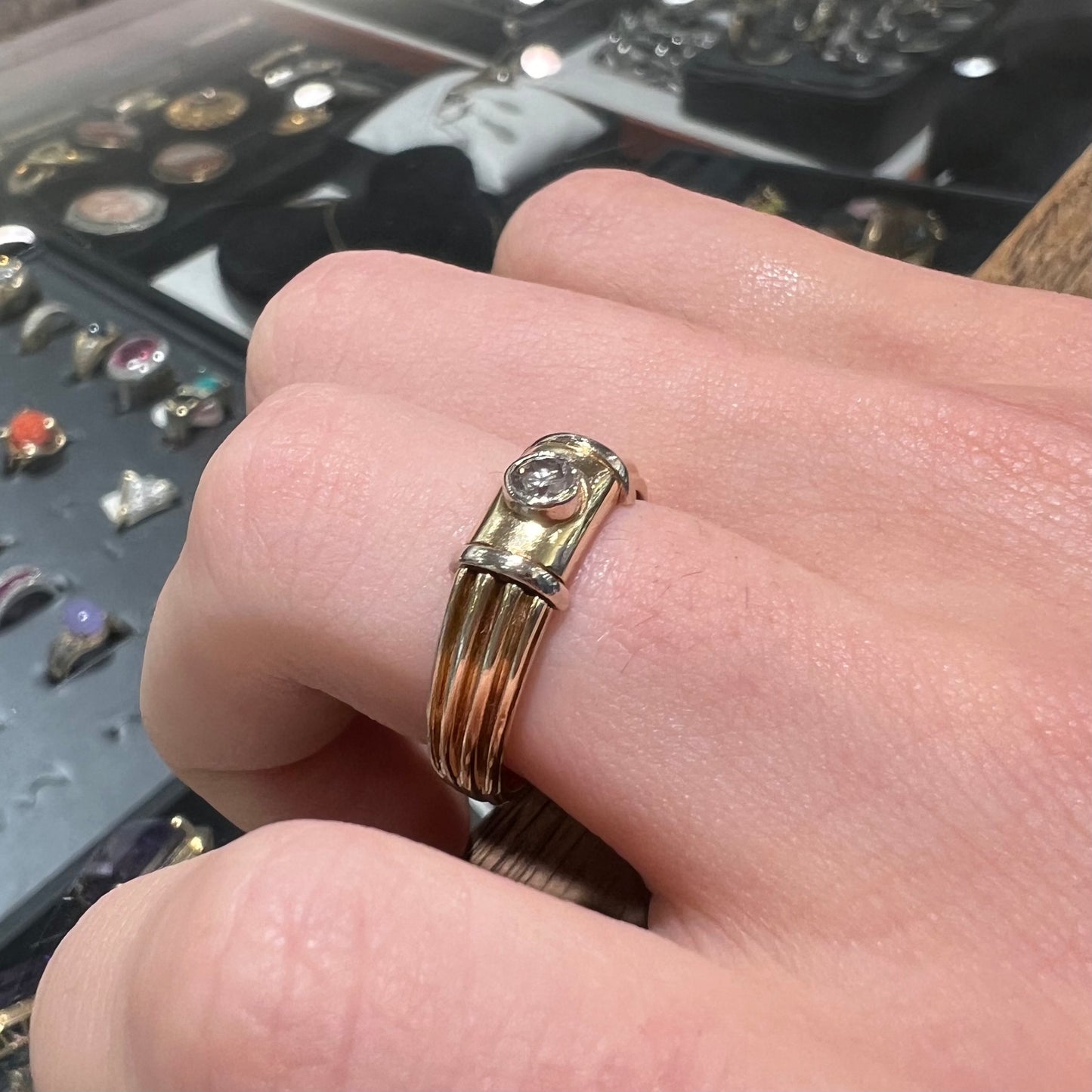 A unisex, vintage style two tone yellow and white gold wedding ring bezel set with a round diamond.