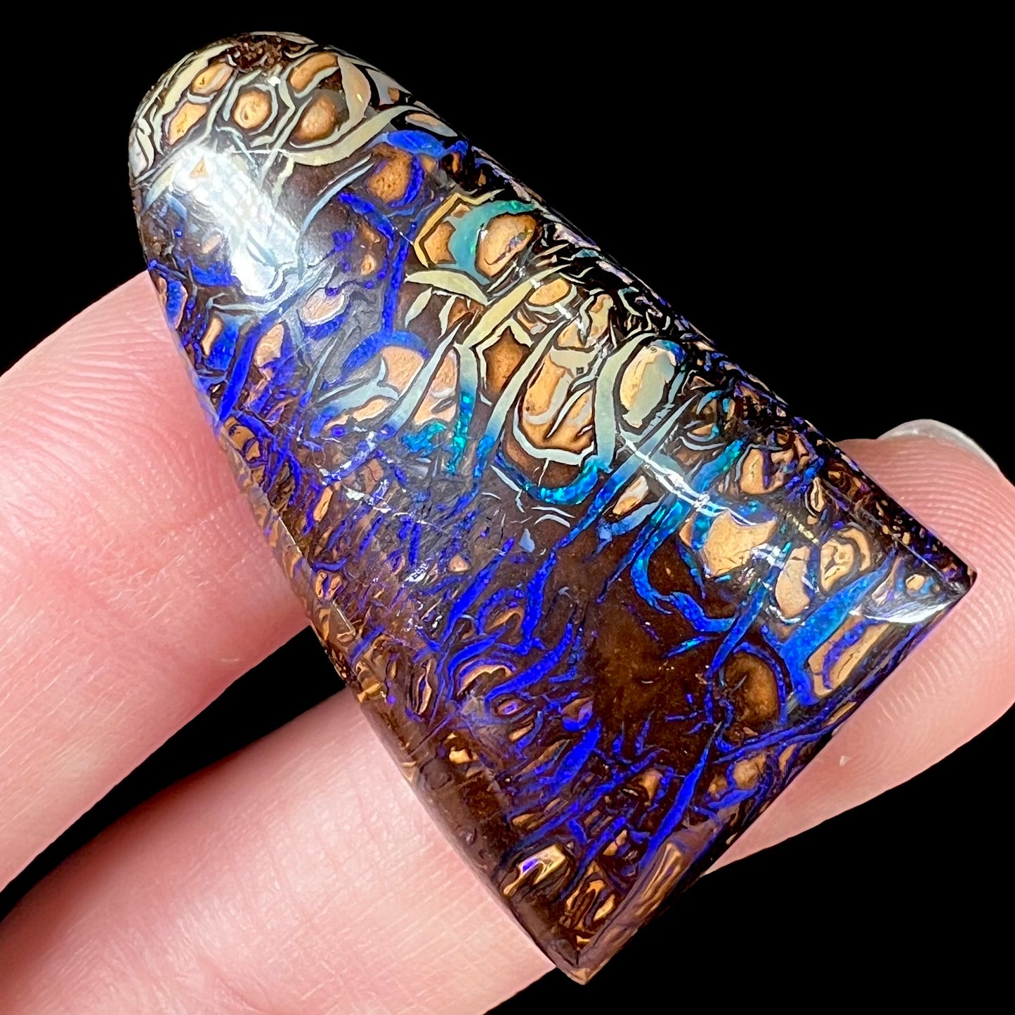 A loose boulder opal stone from Koroit, Australia. The opal has a blue and purple pattern.
