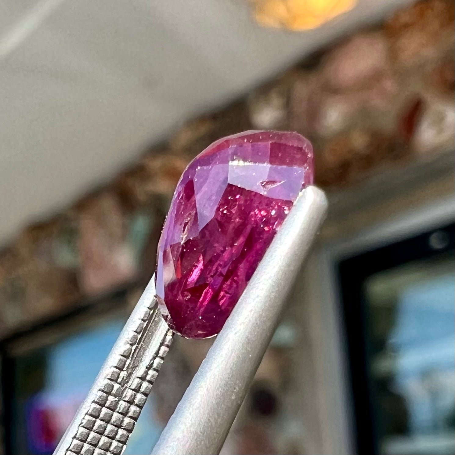 A loose, natural purplish ruby gemstone.  There is a small, minute chip on the girdle of the gem.