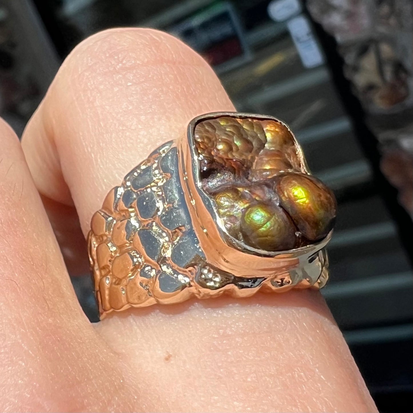 A men's yellow gold, nugget style ring set with a bubbly, California fire agate stone.