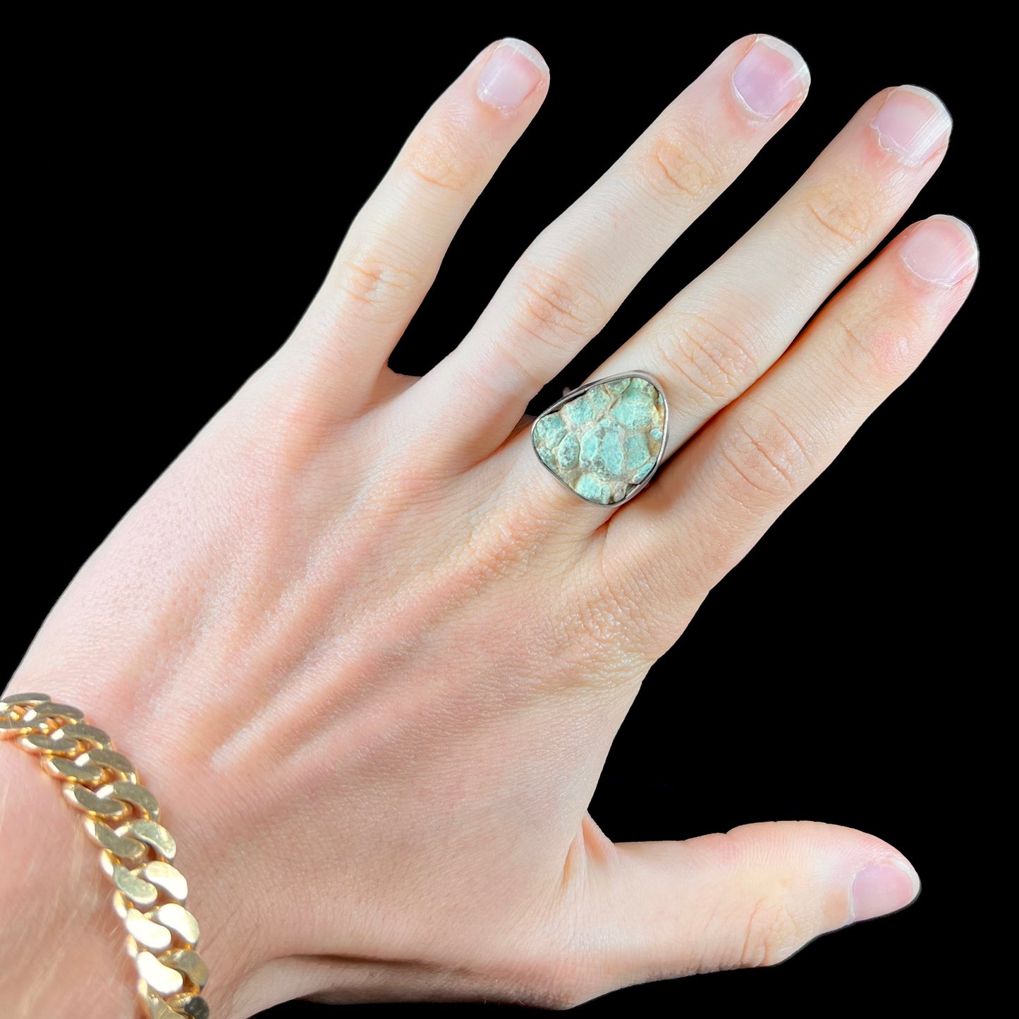 A handmade unisex sterling silver solitaire ring set with a rough, unpolished piece of turquoise stone.