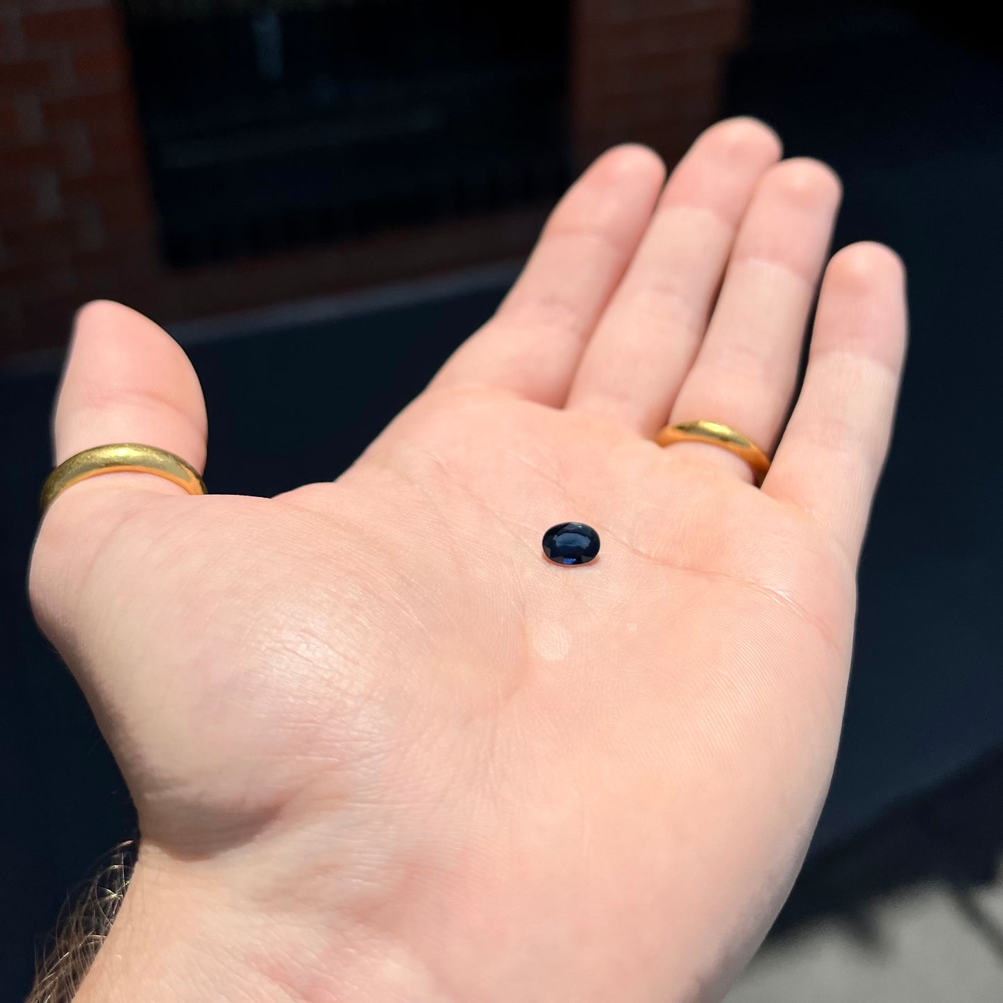 A loose, faceted oval cut natural blue sapphire gemstone.