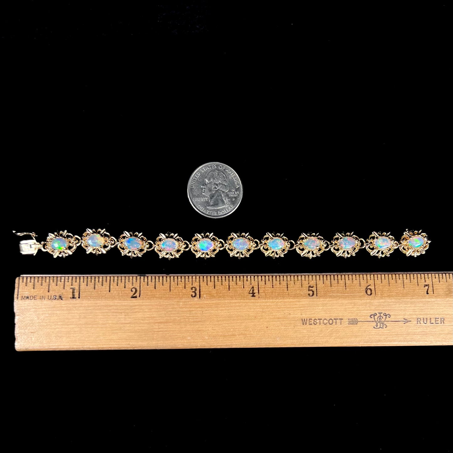 A ladies' yellow gold bracelet set with natural, oval cabochon cut white crystal opals.