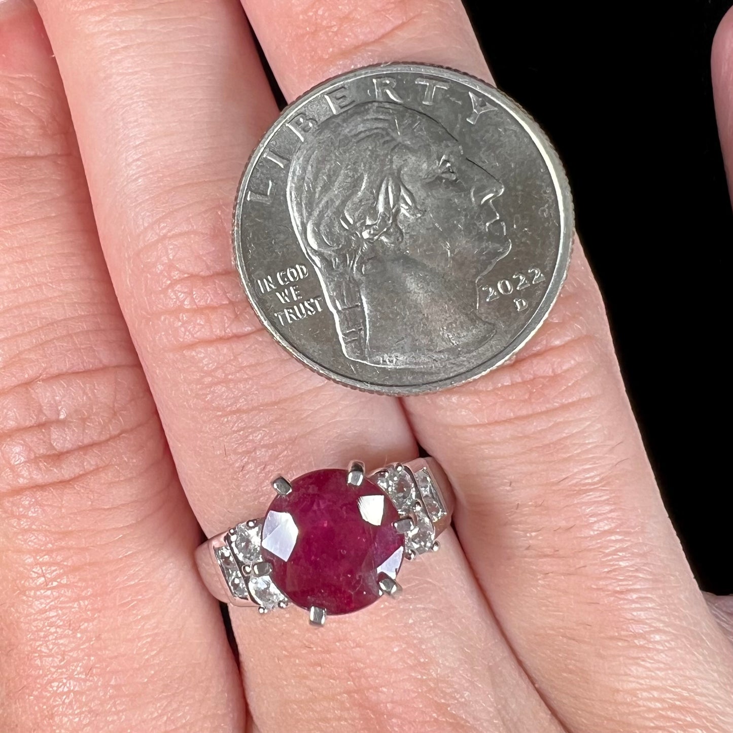 A ladies' sterling silver natural ruby and white zircon ring. The real ruby is glass filled.