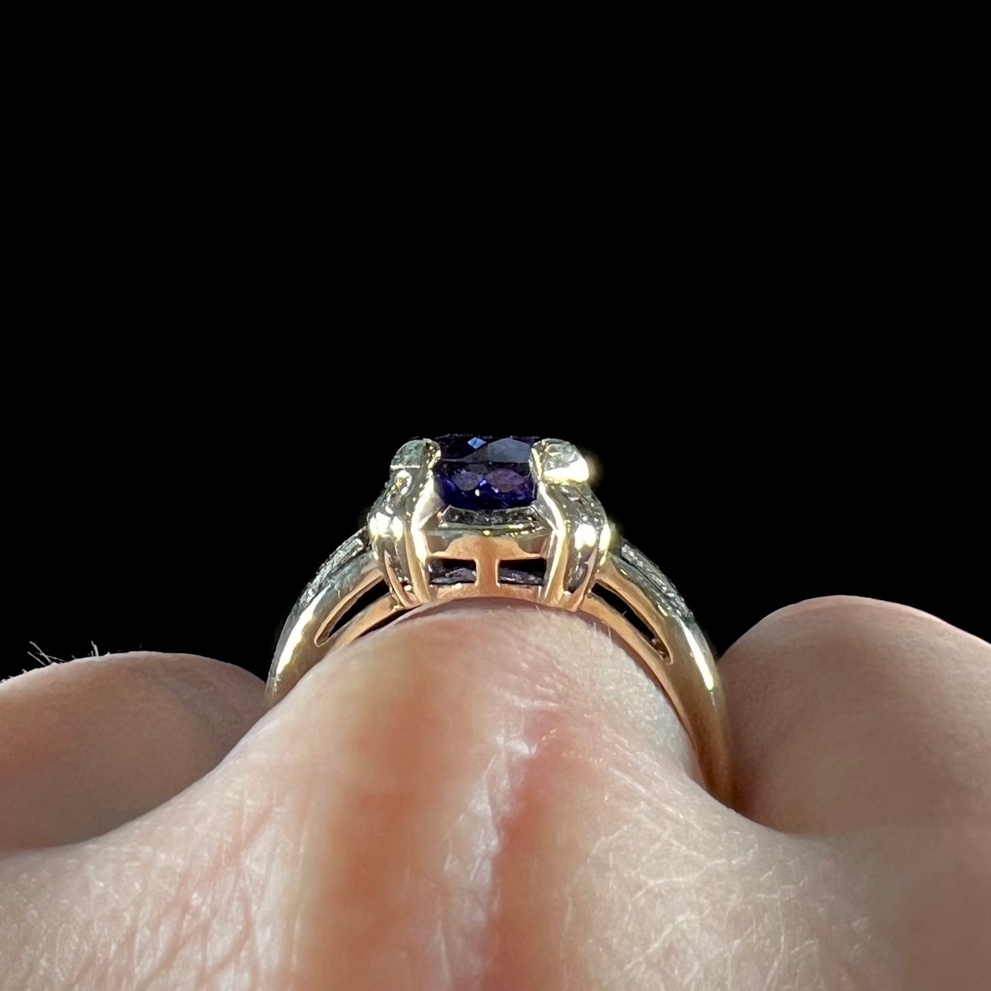 A ladies' yellow gold natural tanzanite and diamond ring. Diamonds are channel set along the shank and in the prongs.