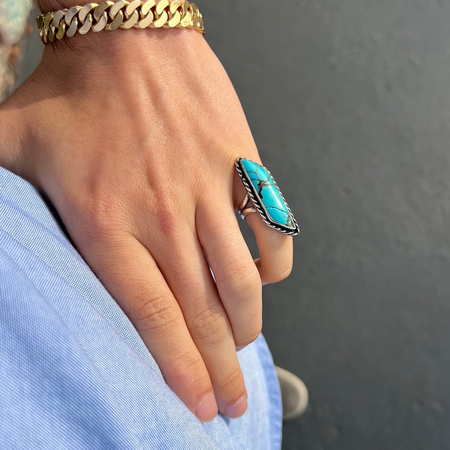 A vintage, Southwest style sterling silver ring set with a natural turquoise stone. The stone is blue with a black matrix.