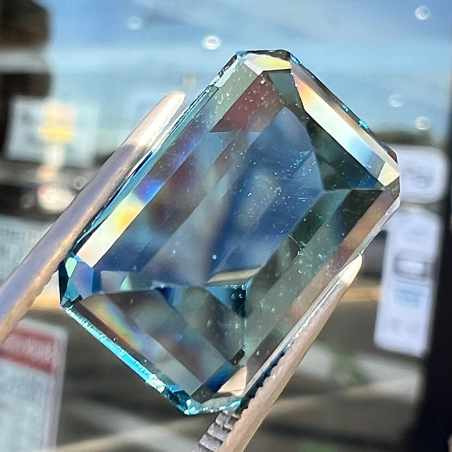A loose, emerald cut London blue topaz gemstone. The stone is a deep, dark blue color.