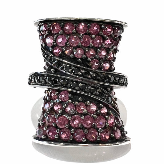 A ladies' bow-shaped designer ring pave set with purple rhodolite garnets and black spinel accents.