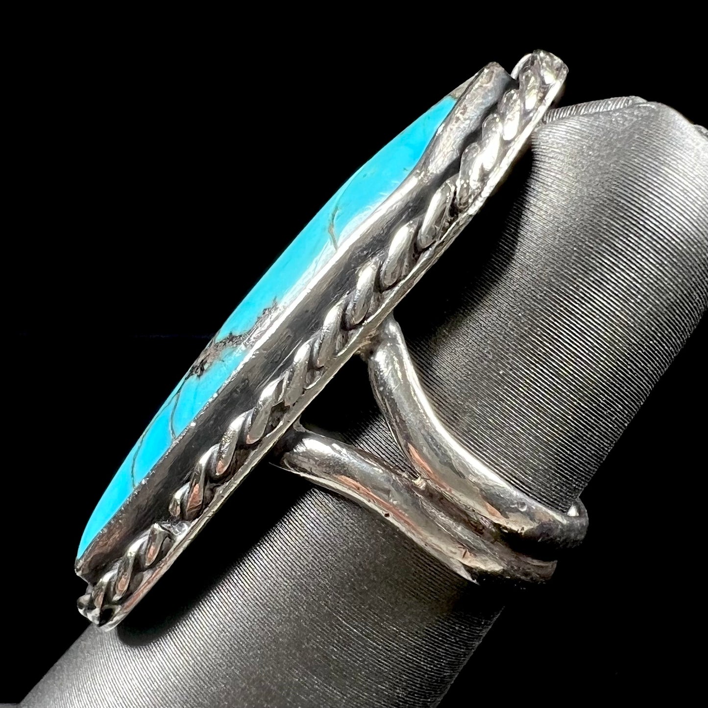A vintage, Southwest style sterling silver ring set with a natural turquoise stone. The stone is blue with a black matrix.