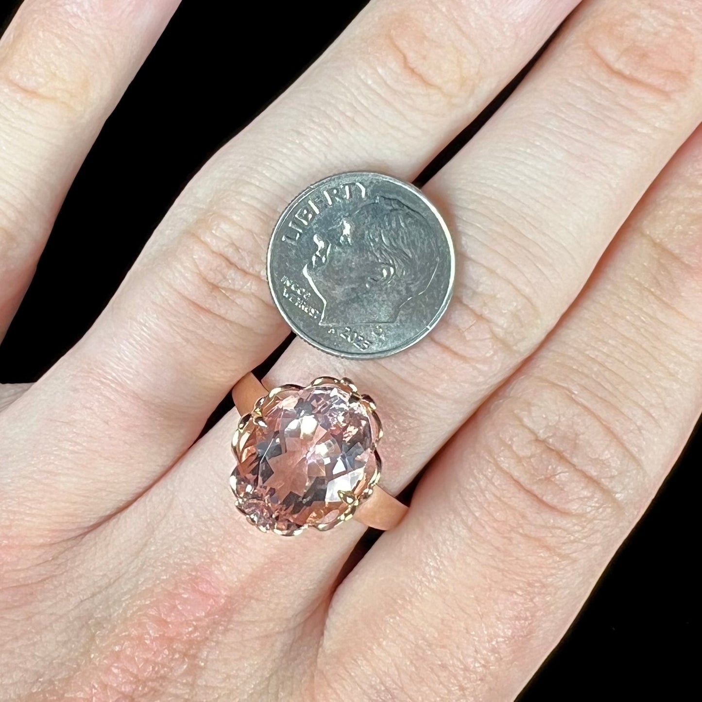 A ladies' rose gold solitaire ring set with an oval cut pink morganite gemstone.