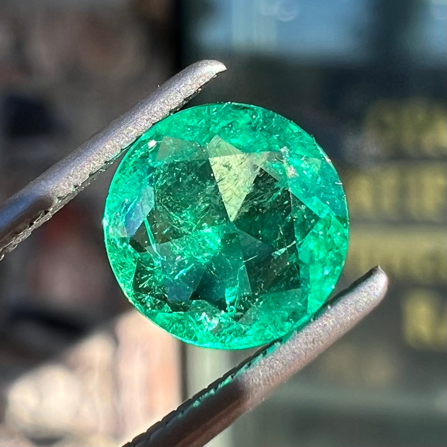 A loose, round brilliant cut natural emerald stone.