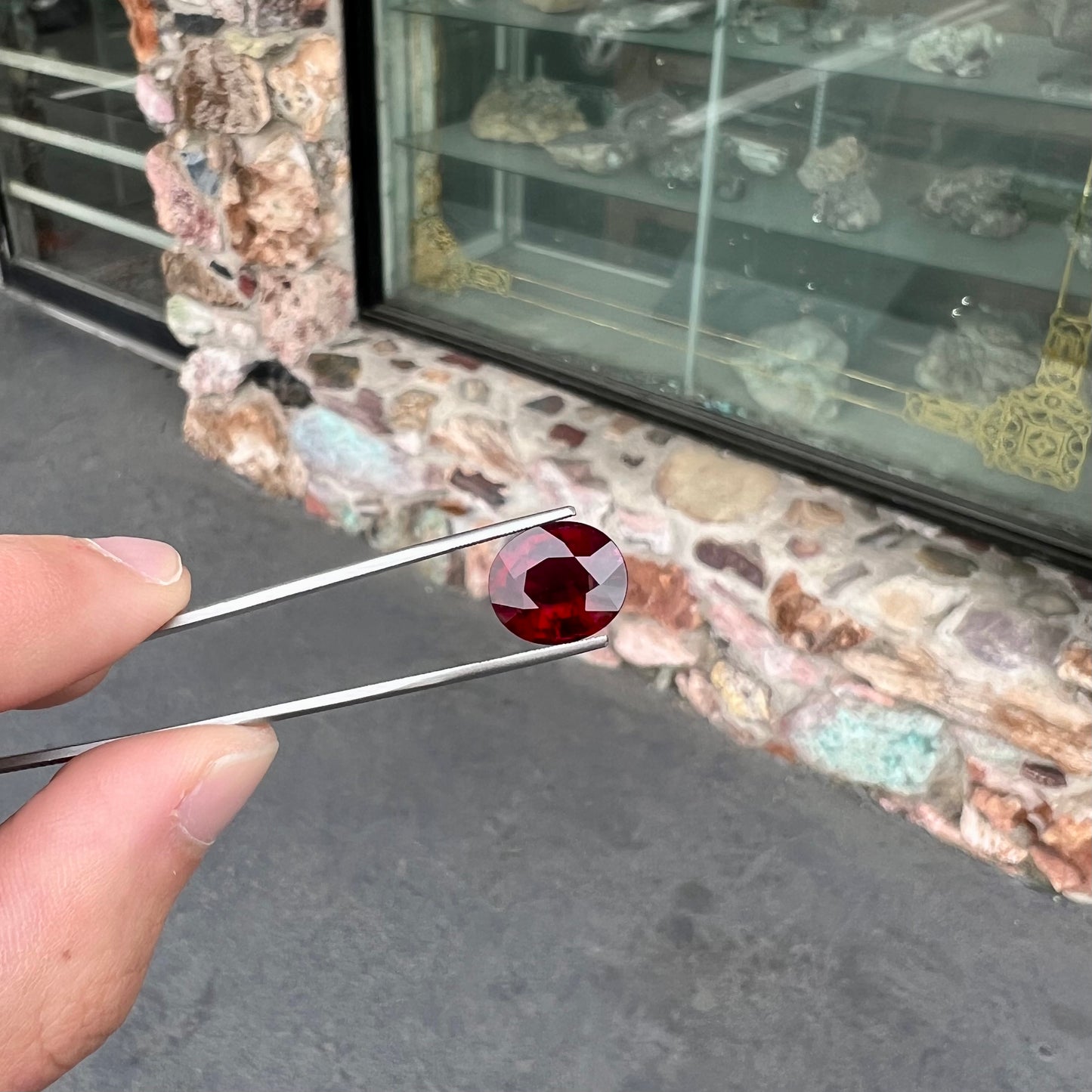 A loose, oval cut purplish red rubellite tourmaline stone.