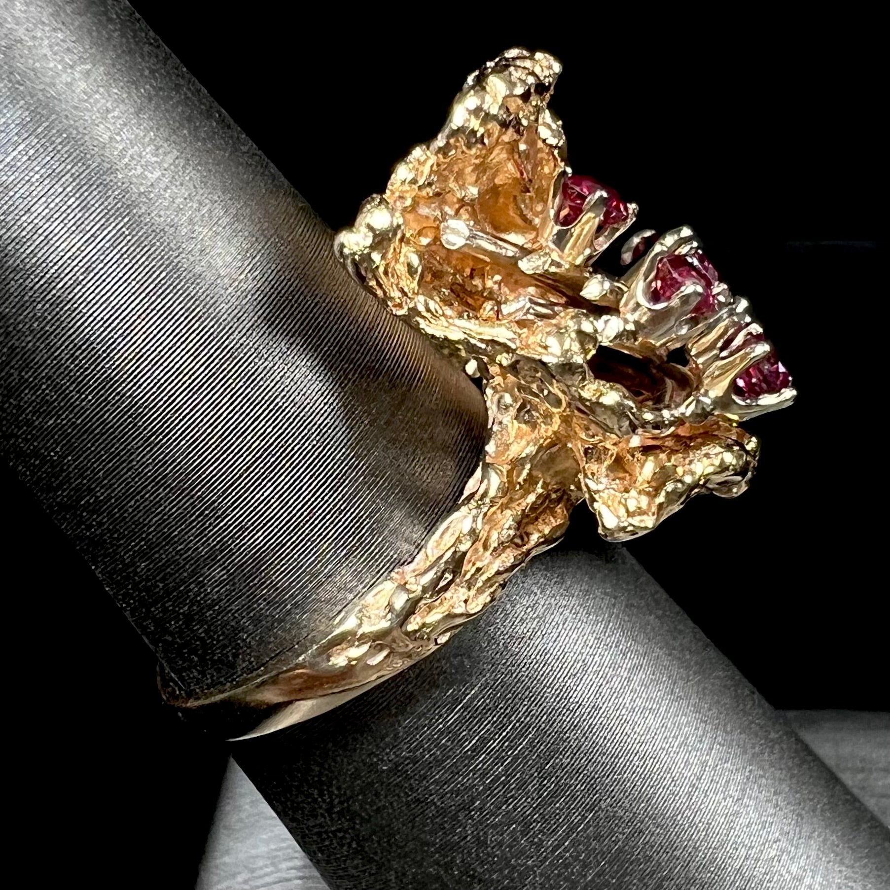 A yellow gold ruby cluster ring from the 1950's.  There is one oval cut ruby and five round cut rubies.