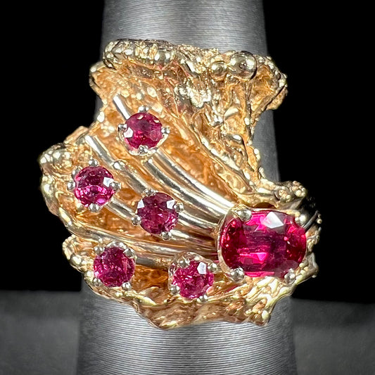 A yellow gold ruby cluster ring from the 1950's.  There is one oval cut ruby and five round cut rubies.
