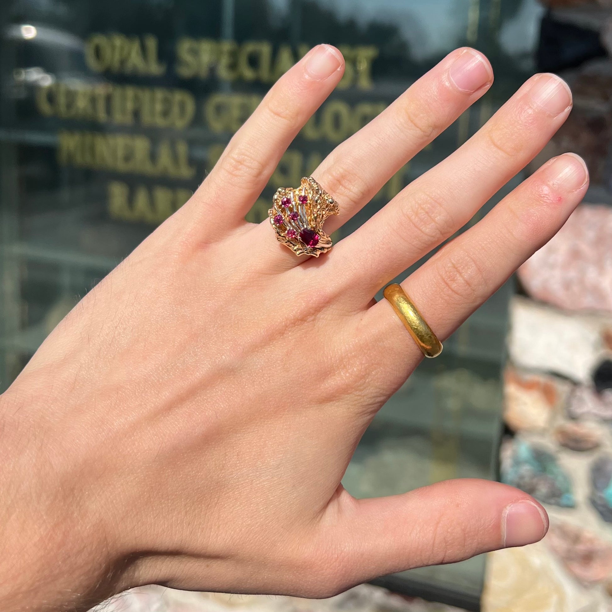 A yellow gold ruby cluster ring from the 1950's.  There is one oval cut ruby and five round cut rubies.