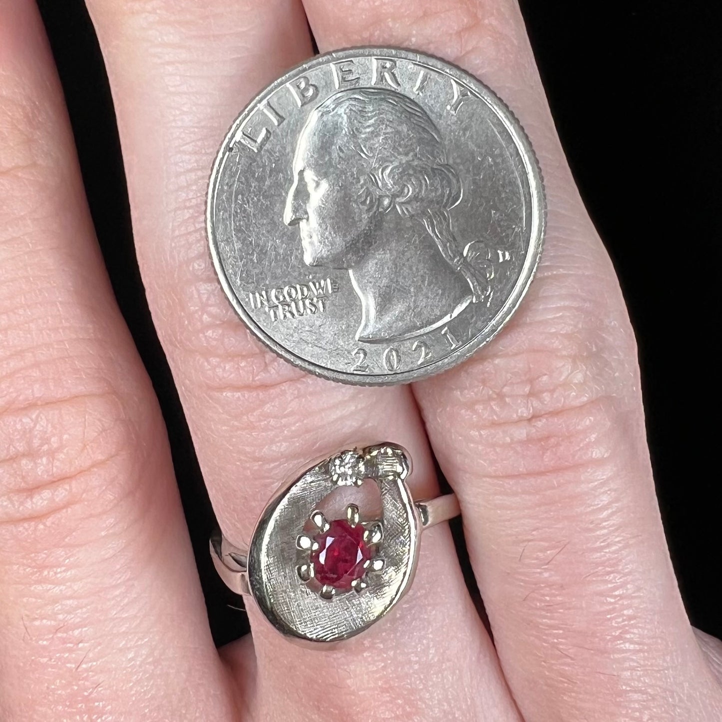 A ladies' estate white gold ruby ring set with a diamond accent stone.