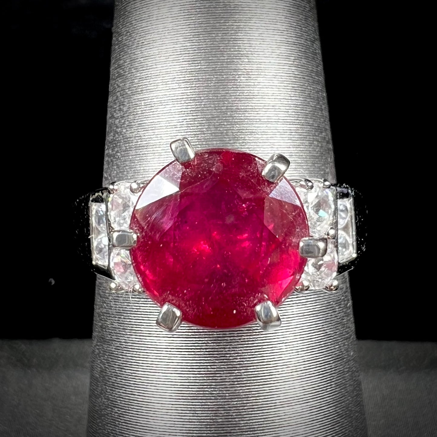 A ladies' sterling silver natural ruby and white zircon ring. The real ruby is glass filled.