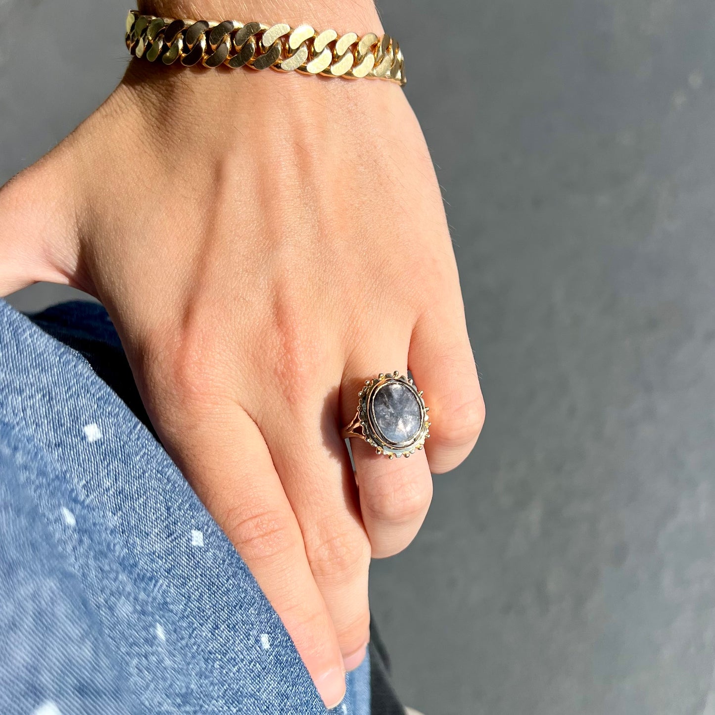 A ladies' yellow gold solitaire ring mounted with a gray trapiche star sapphire.