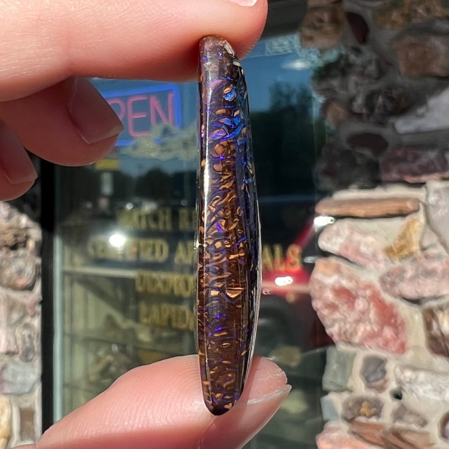 A loose boulder opal stone from Koroit, Australia. The opal has a blue and purple pattern.