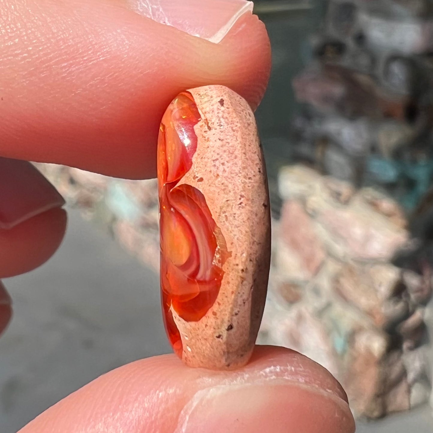A loose Mexican matrix fire opal stone. The opal is orange with green flashes.