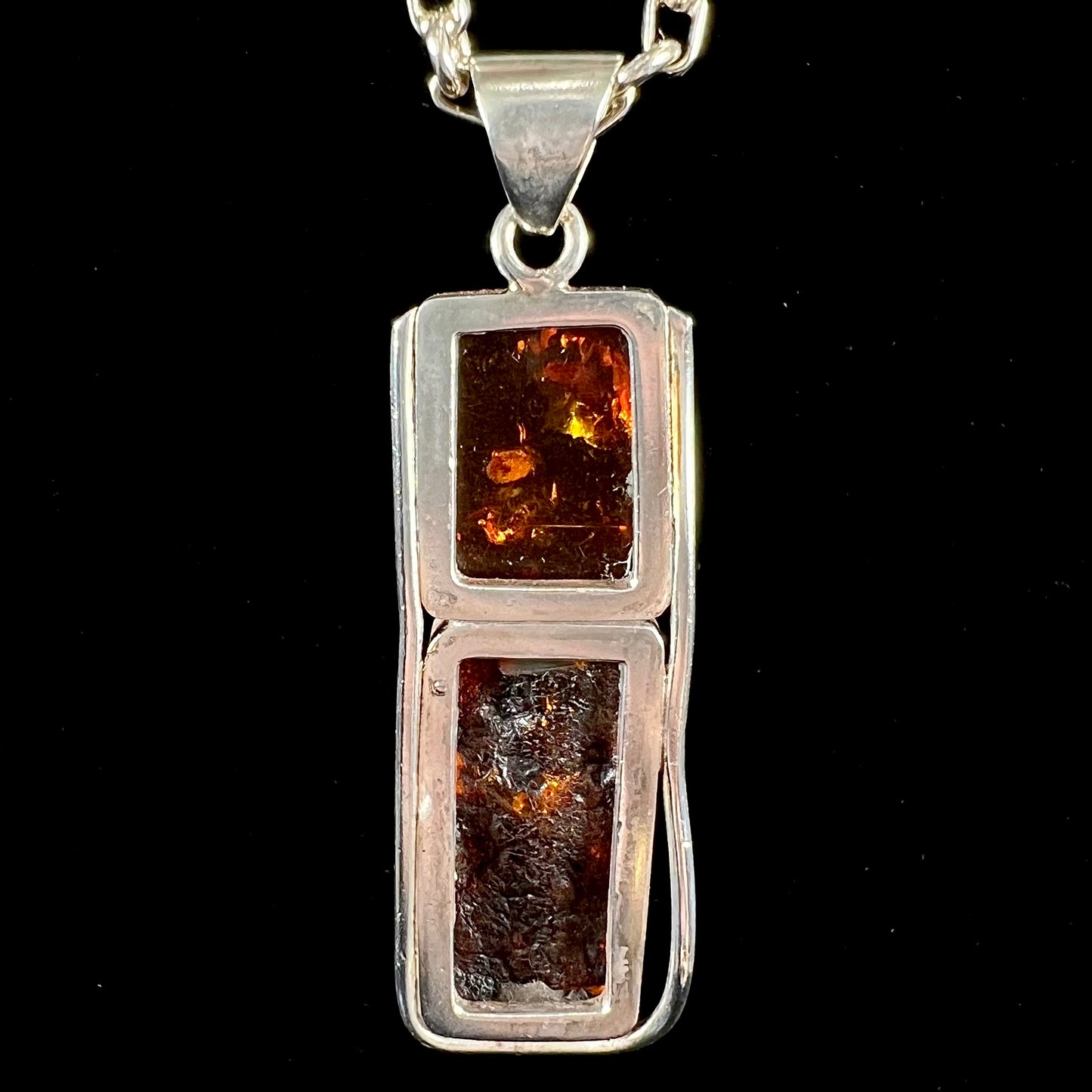 A sterling silver pendant set with two rectangle shaped natural amber cabochons.