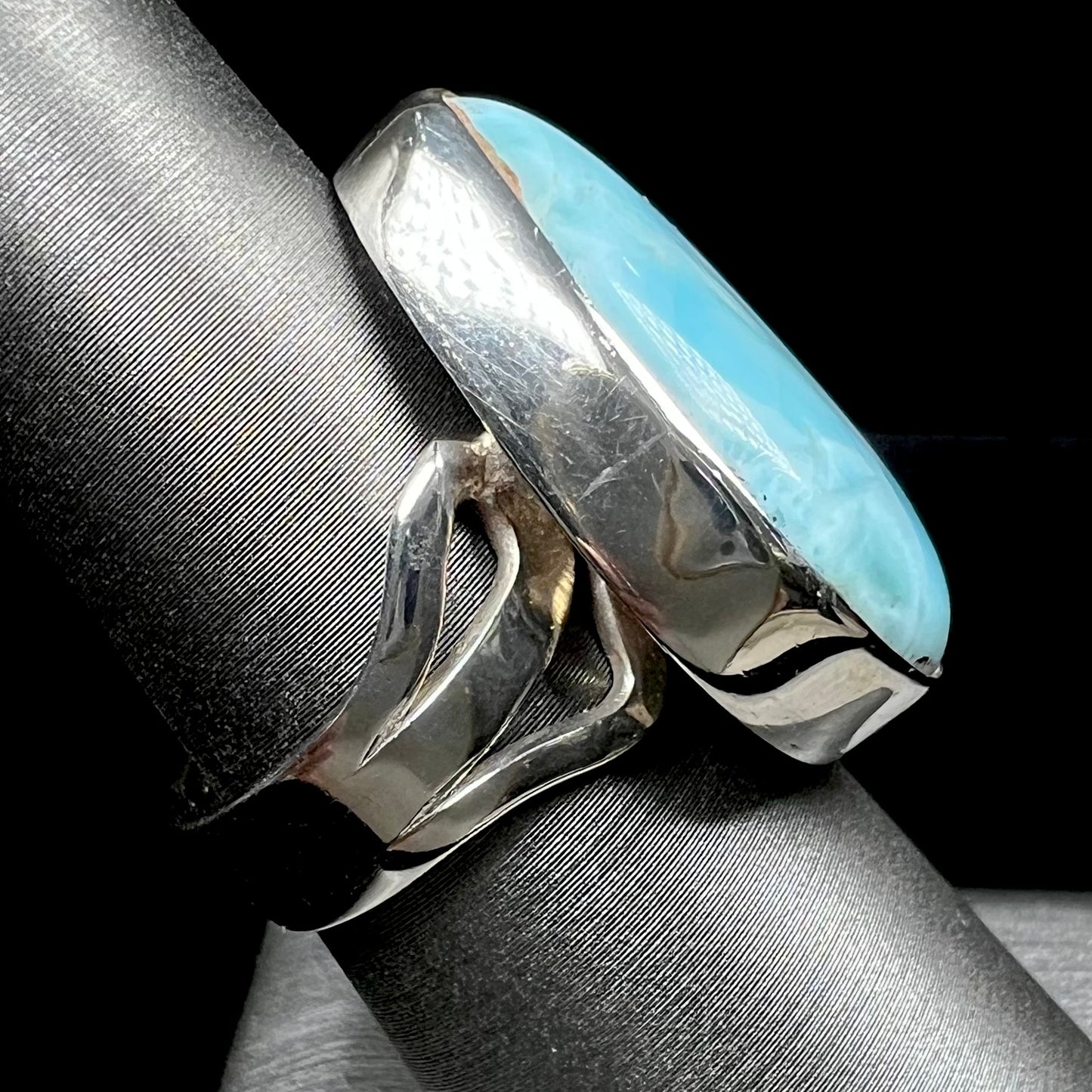 A ladies' large, pear shaped larimar solitaire ring in sterling silver. The larimar stone measures an inch long.