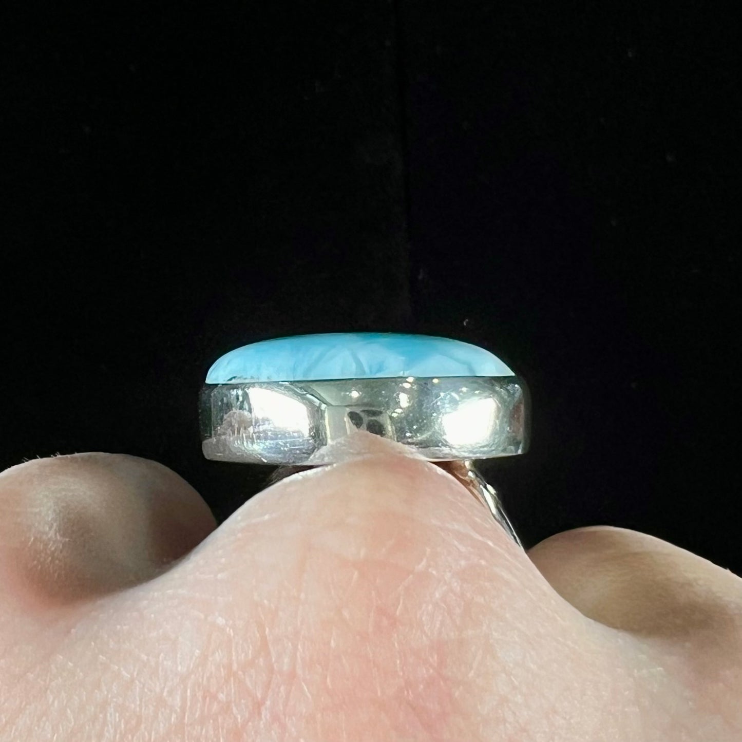 A ladies' large, pear shaped larimar solitaire ring in sterling silver. The larimar stone measures an inch long.