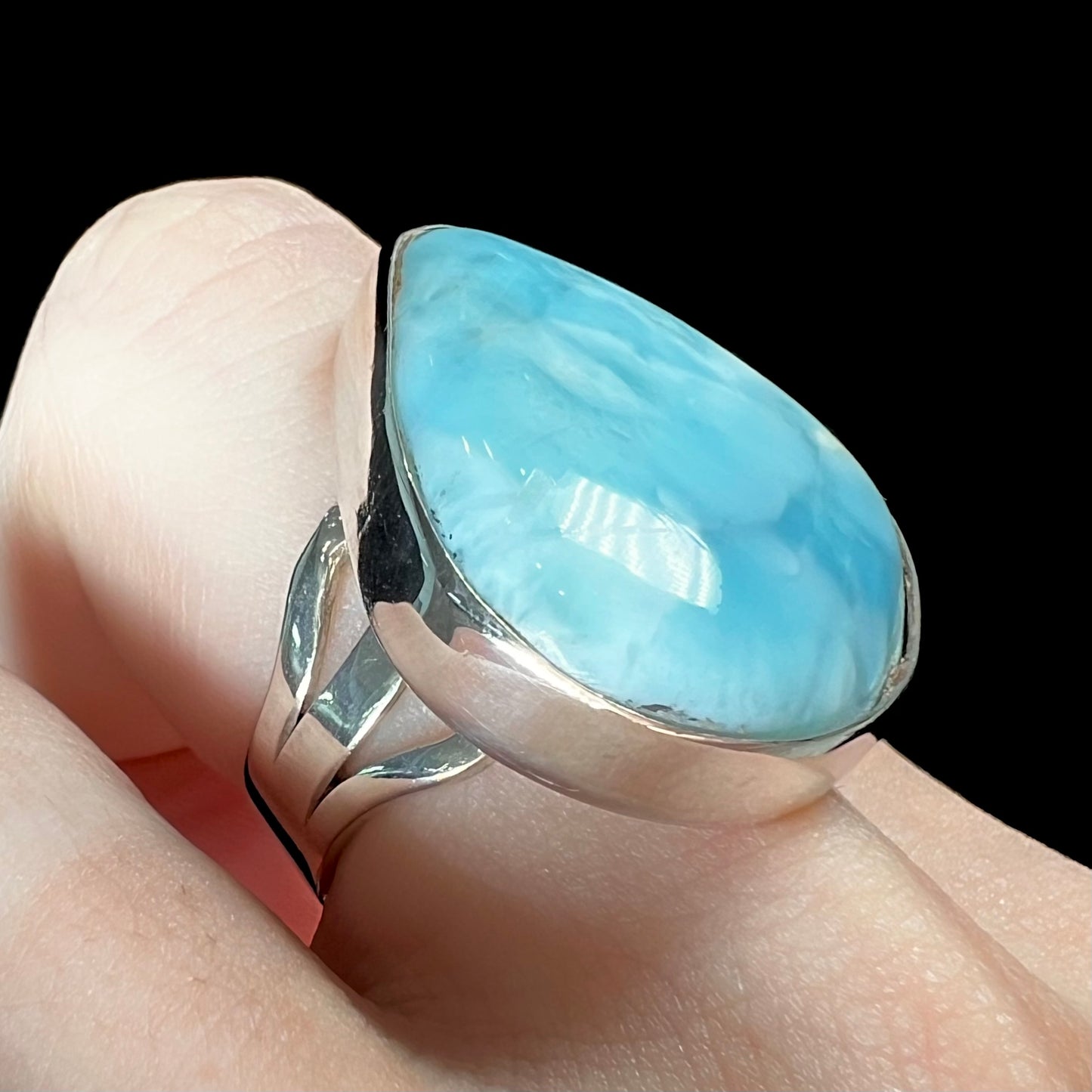 A ladies' large, pear shaped larimar solitaire ring in sterling silver. The larimar stone measures an inch long.