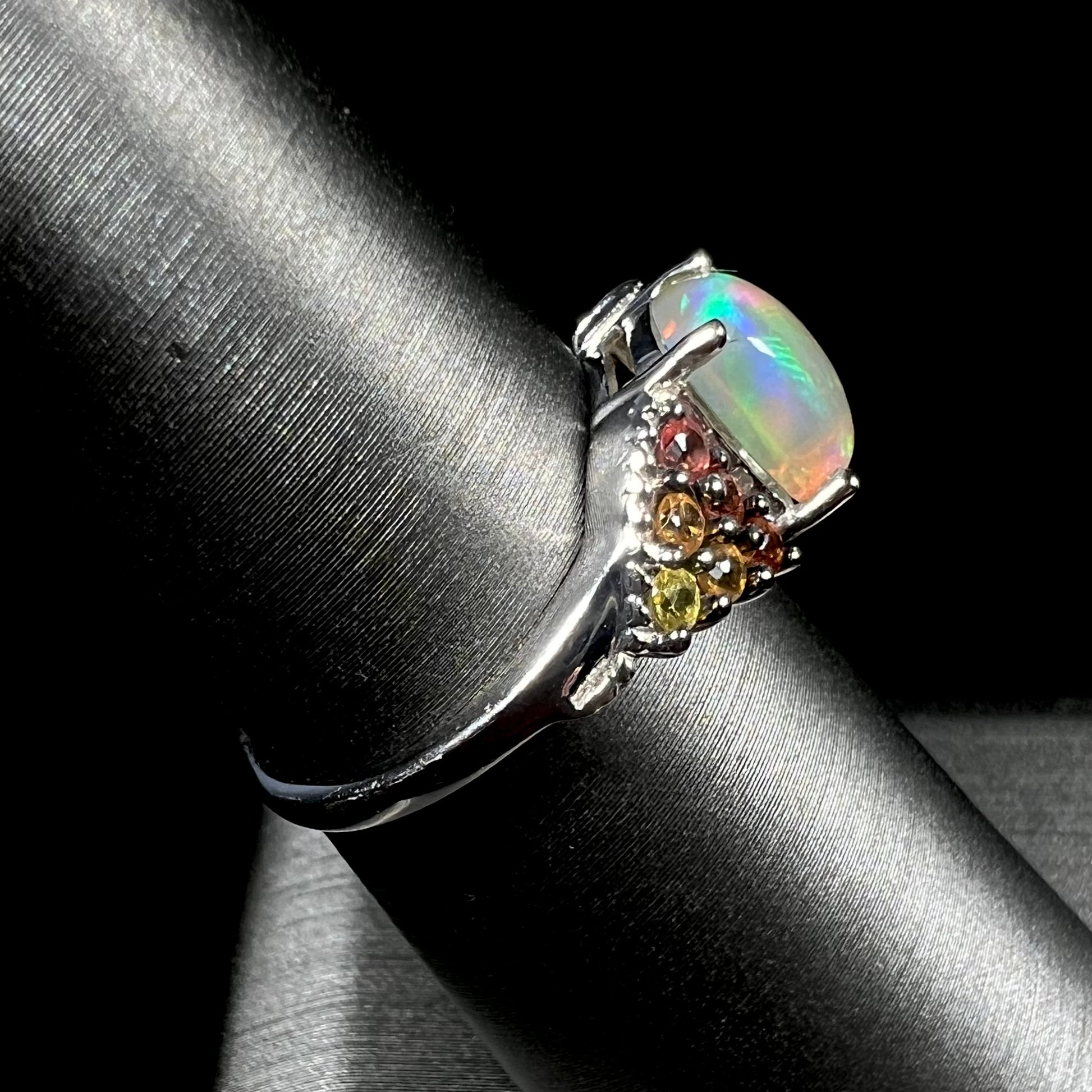 A ladies' silver ring set with a cushion cabochon cut Ethiopian fire opal stone and citrine accents.