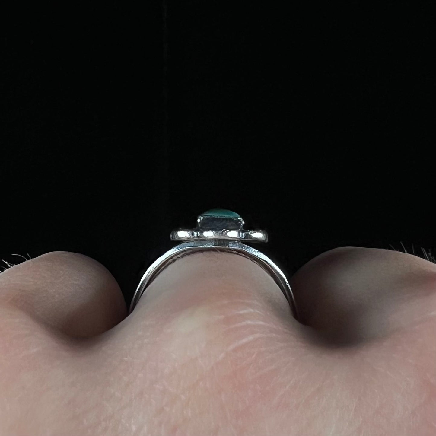 A ladies' silver ring stamped with Southwest style designs and set with a rectangular cabochon cut Royston turquoise stone.