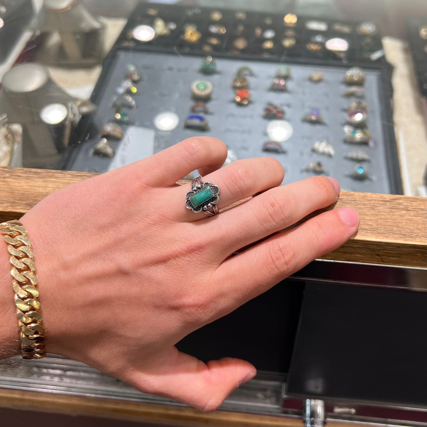A ladies' silver ring stamped with Southwest style designs and set with a rectangular cabochon cut Royston turquoise stone.