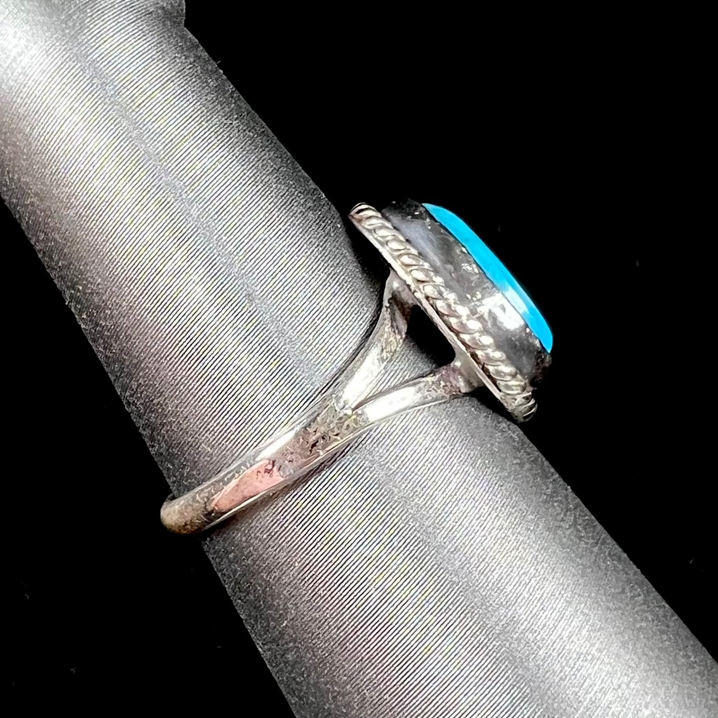 A vintage ladies' Pilot Mountain turquoise ring handmade in sterling silver with a rope accented bezel.