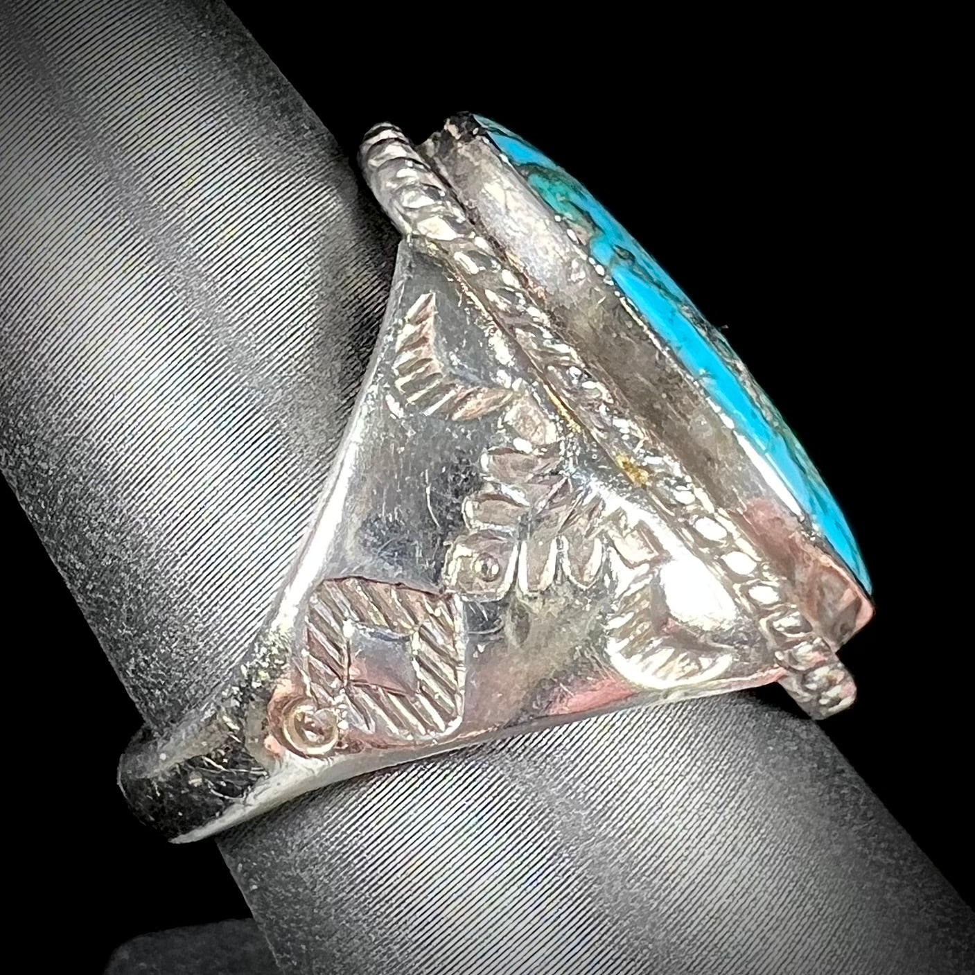 A men's sterling silver Morenci turquoise solitaire ring. The ring has a Southwest Navajo style stamp pattern.