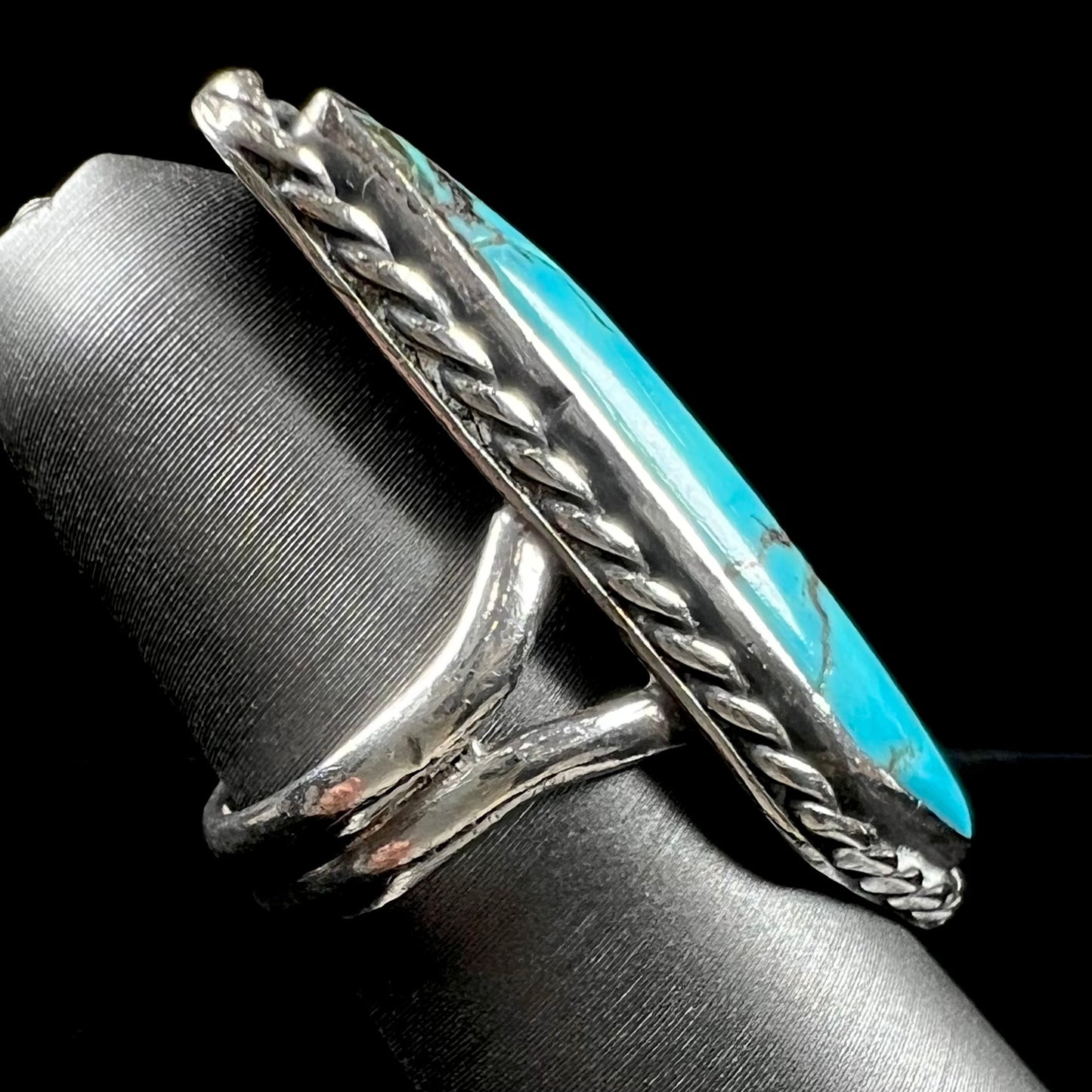 A vintage, Southwest style sterling silver ring set with a natural turquoise stone. The stone is blue with a black matrix.