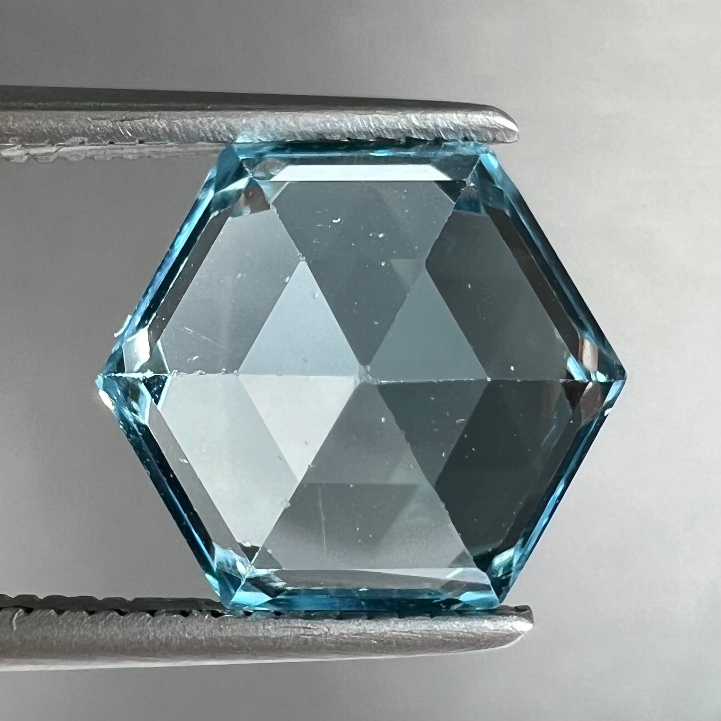 A faceted hexagon cut sky blue topaz gemstone.