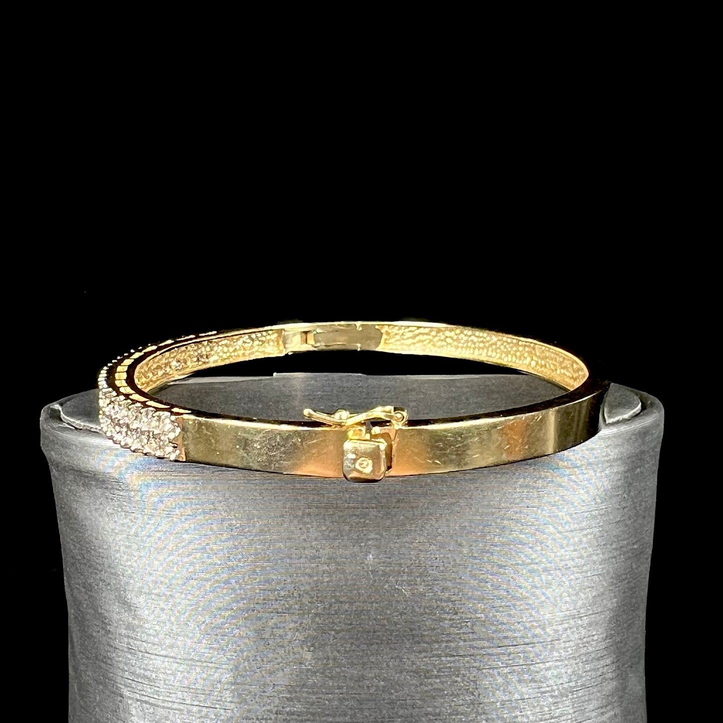 A ladies' hinged yellow gold bangle bracelet set with 50 Standard Round Brilliant Cut diamonds.