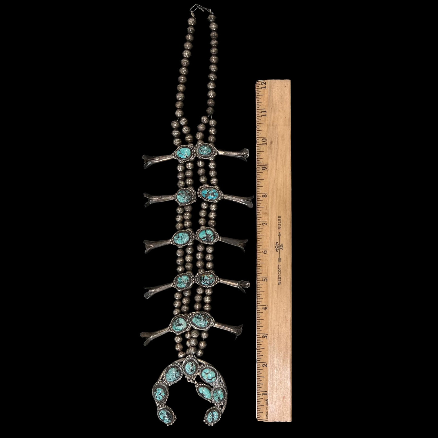 A Native American squash blossom necklace set with Number 8 MIne turquoise stones.