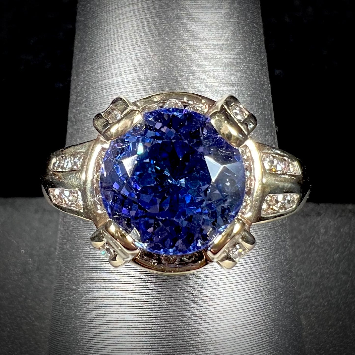 A ladies' yellow gold natural tanzanite and diamond ring. Diamonds are channel set along the shank and in the prongs.