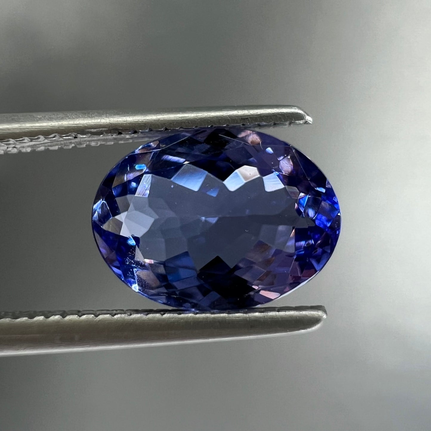 A loose, oval cut tanzanite gemstone.