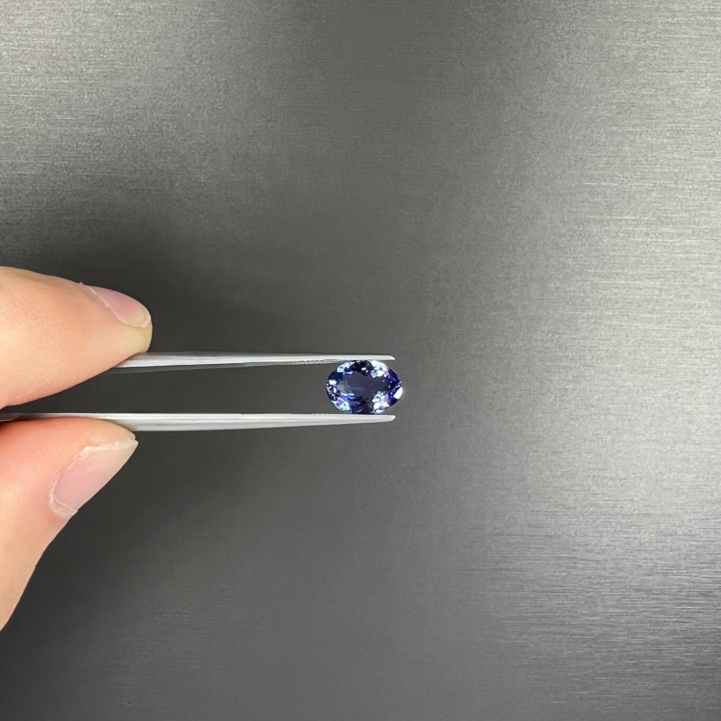 A loose, oval cut tanzanite gemstone.