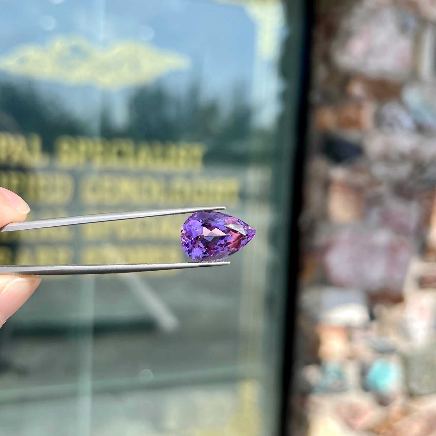 A loose, pear shaped amethyst gemstone. The stone is a medium purple color.