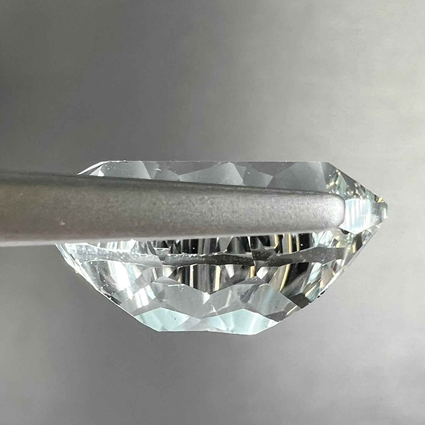 A loose, modified laser cushion cut white topaz gemstone.