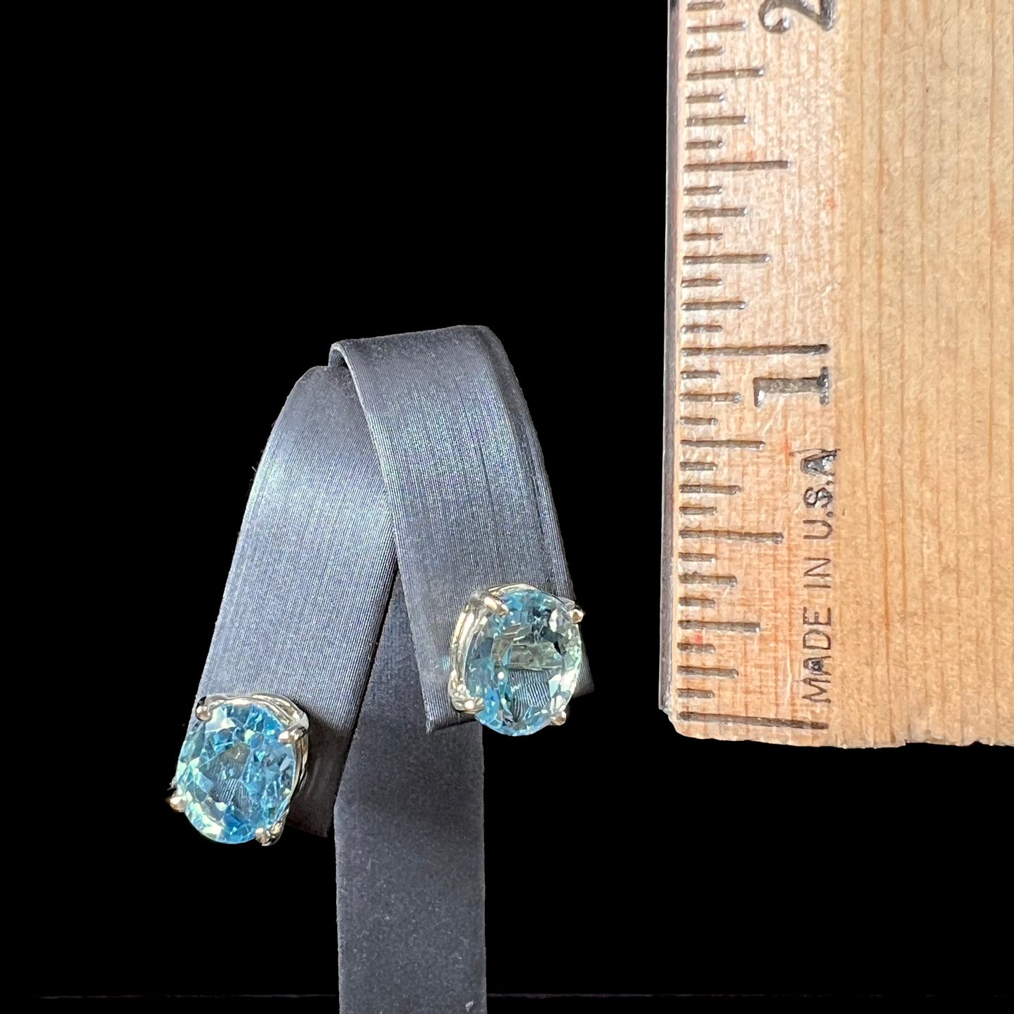 A pair of yellow gold push-back blue topaz stud earrings.