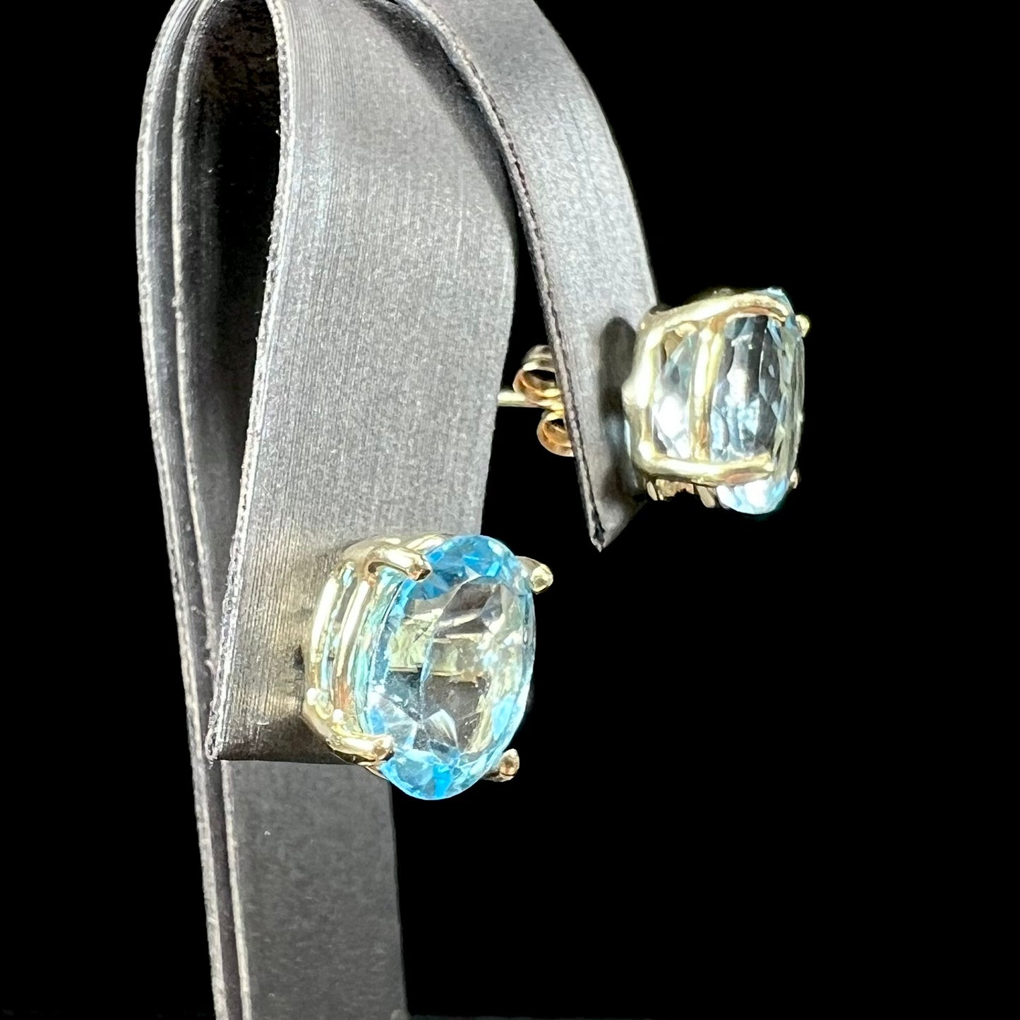 A pair of yellow gold push-back blue topaz stud earrings.