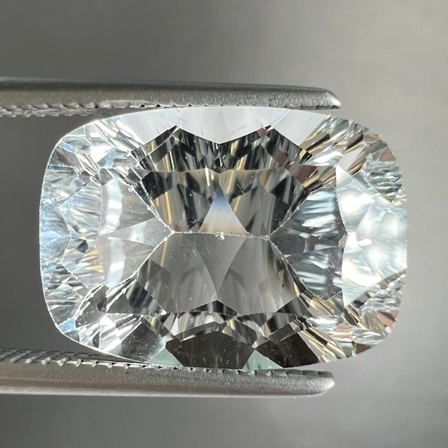 A loose, modified laser cushion cut white topaz gemstone.